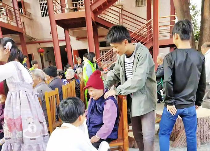 同学们为老人揉肩按摩